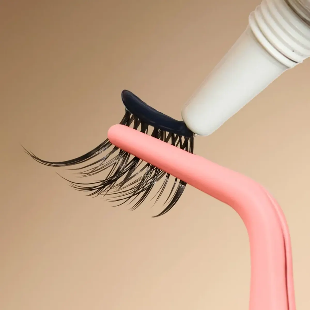 Pre-glued cluster lashes DIY glue-free waterproof lash extensions held with pink tweezers close-up product shot